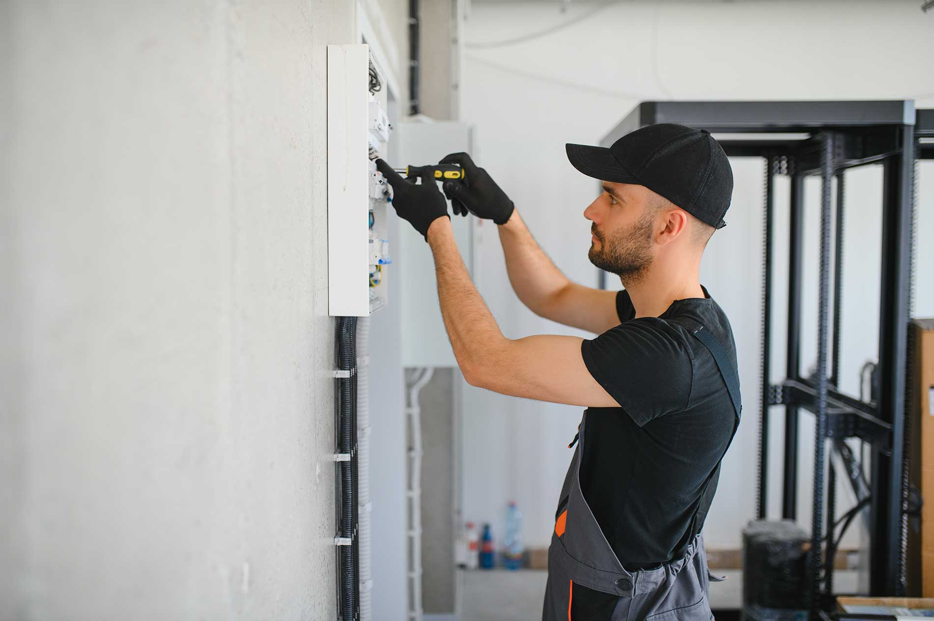 electrician working in a switchboard with fuses