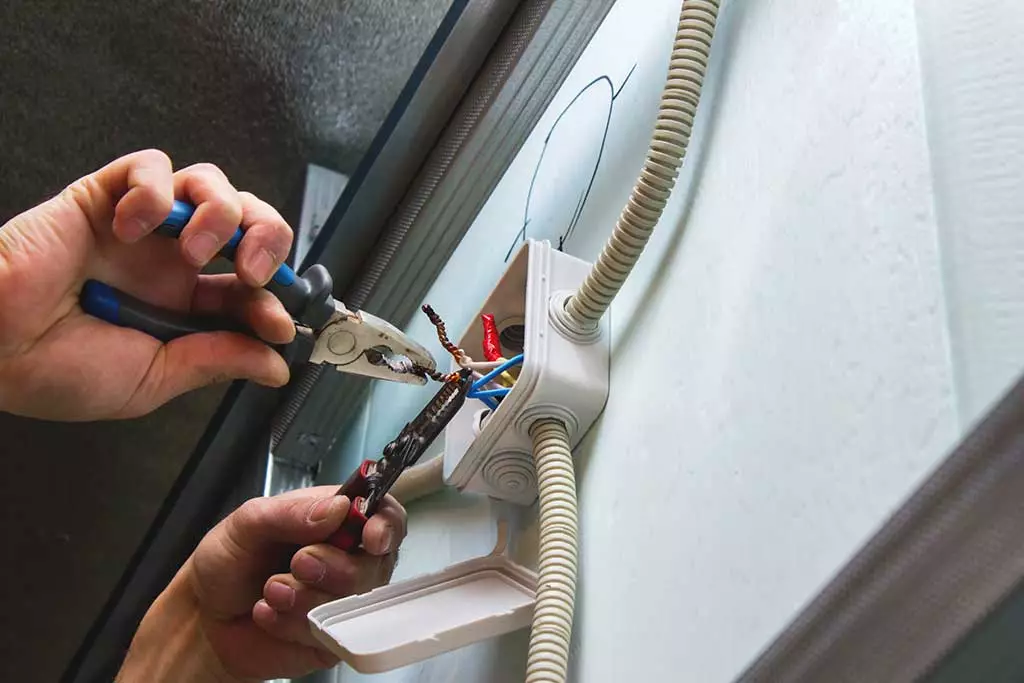 electrical worker adjusting the wires on an outlet
